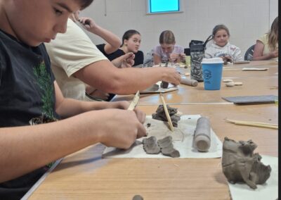 Children crafting with clay during summer craft session.