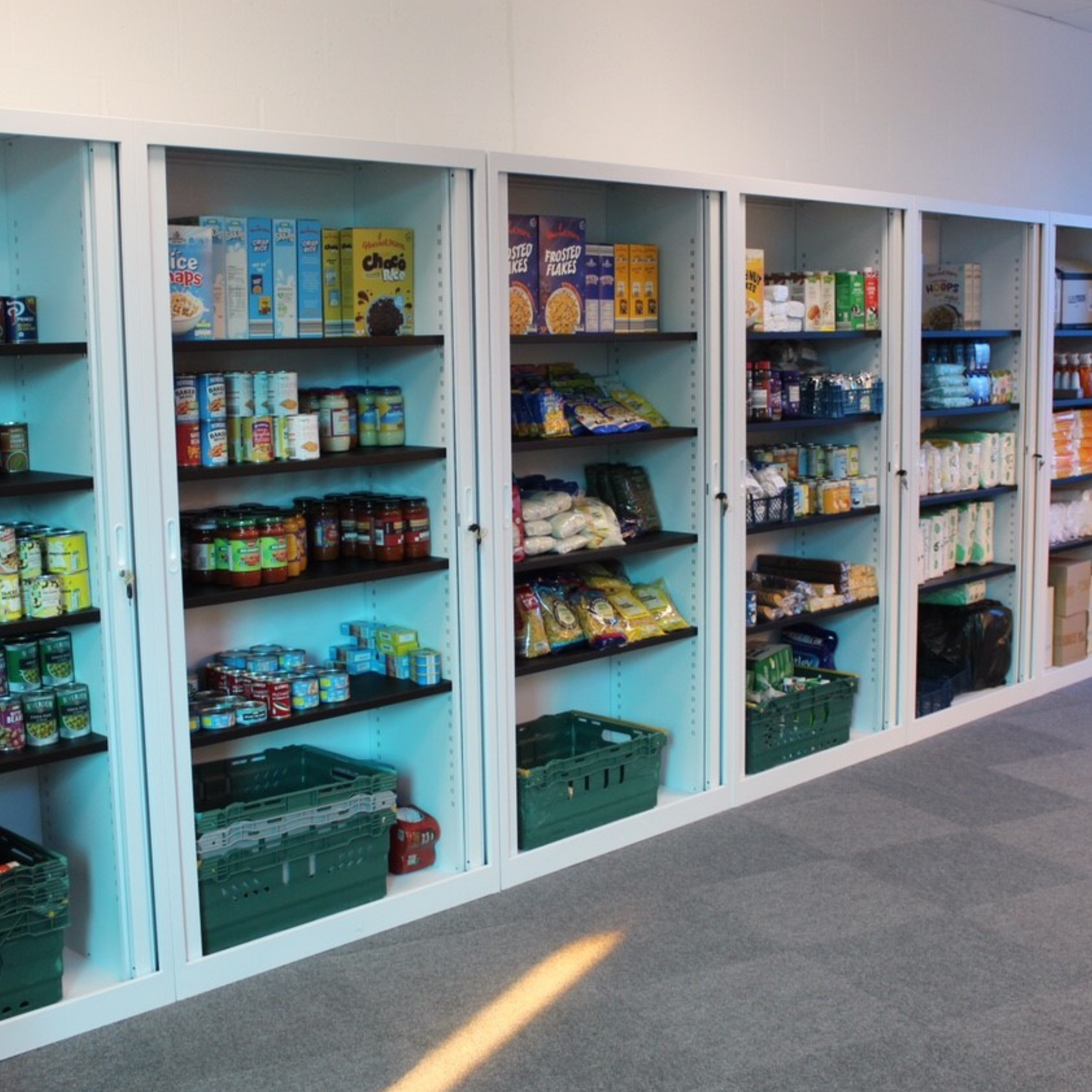 The image depicts the Bourne Community Food store with shelfs full of food items.